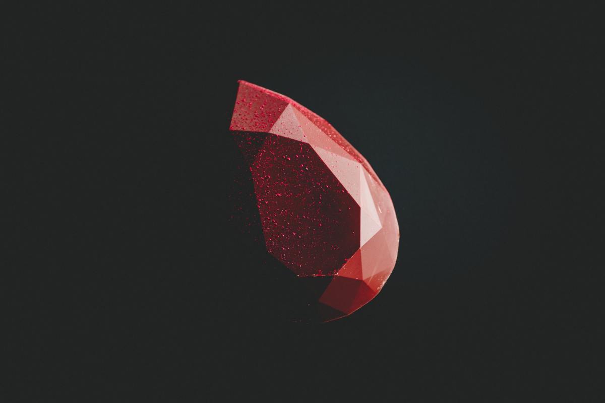 a ruby gemstone before a dark background. This is a reference to Ruby, the programming language.
